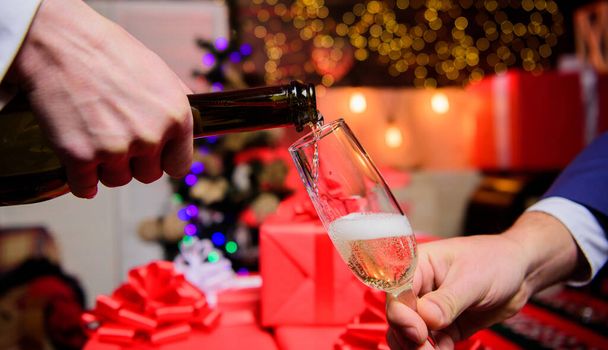 Drink champagne or sparkling wine. Celebrate new year with champagne. Hands pouring champagne into elegant glass christmas decorations background. Cheers concept. Last minute before new year - Fotó, kép