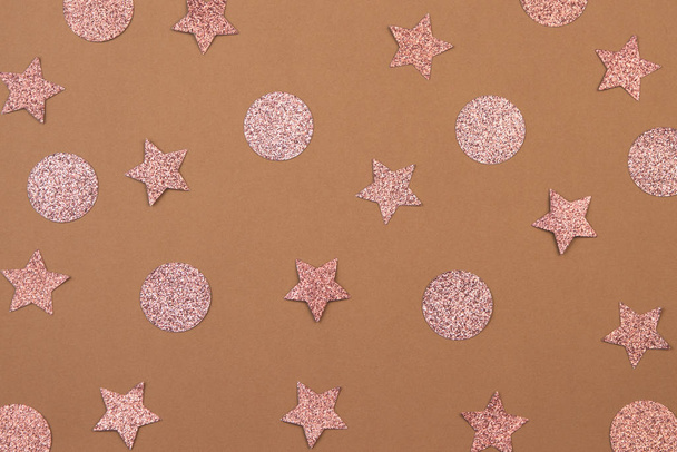 Pink confetti in the shape of a star and a dot on a biege background. Christmas and New Year concept. - Photo, Image