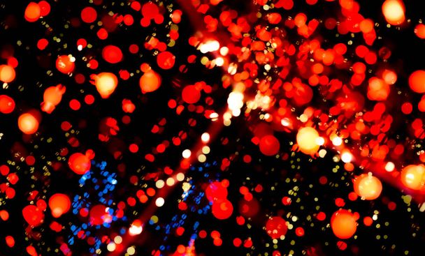 Kerstmis en gelukkig nieuwjaar decoratie licht. rood, blauw, gele kleur bokeh achtergrond met prachtig patroon. Gedeocaliseerd kerstlicht in de nacht van het feest. Kerst vakantie bokeh achtergrond.  - Foto, afbeelding