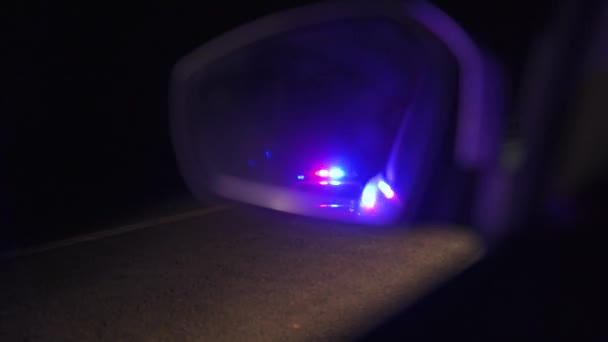 Мигающие полицейские огни отражаются в зеркале заднего вида автомобиля ночью - Кадры, видео