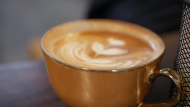 Cup of coffee with latte art. Barista made a beautiful art on milk foam. Close-up - Filmati, video