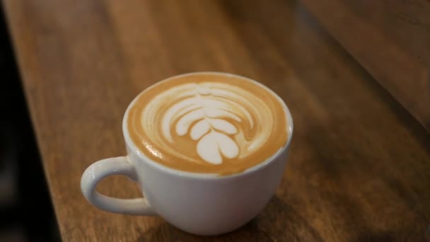 Šálek kávy s latté art. Barista vytvořil krásné umění na mléčné pěně. Detailní záběr - Záběry, video