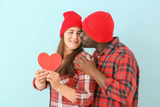 Szczęśliwa para międzyrasowa z czerwonym sercem na tle koloru - Zdjęcie, obraz