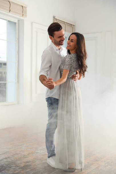 Lovely young couple dancing together in ballroom - Foto, Bild