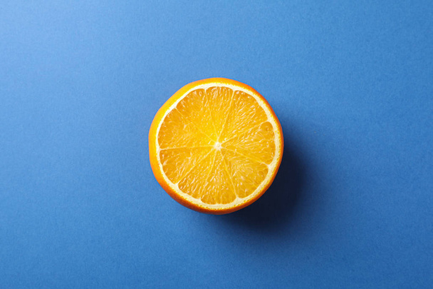 Half of juicy orange on blue background, space for text - Foto, Bild