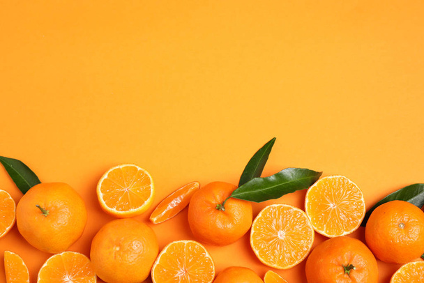 Flat lay composition with fresh ripe tangerines and space for text on orange background. Citrus fruit - Foto, imagen