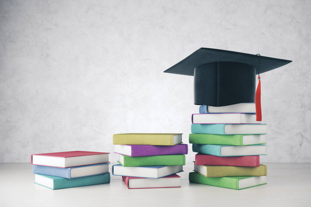 Mortarboard and colorful book pile - Foto, imagen