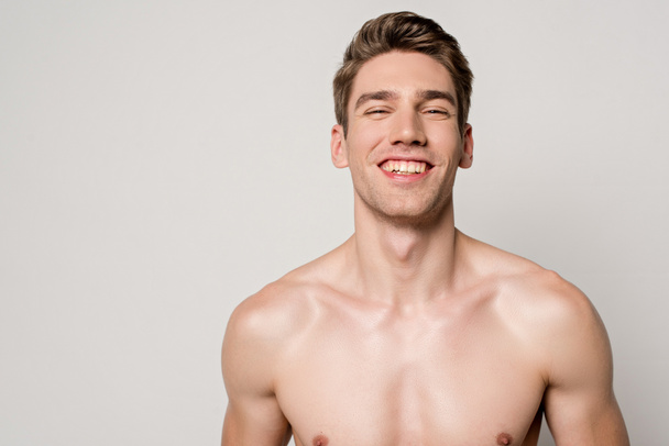 smiling sexy man with muscular torso isolated on grey - Foto, afbeelding