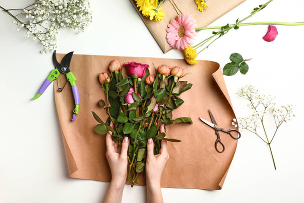 Vrouwelijke bloemist maken mooi boeket op witte achtergrond - Foto, afbeelding