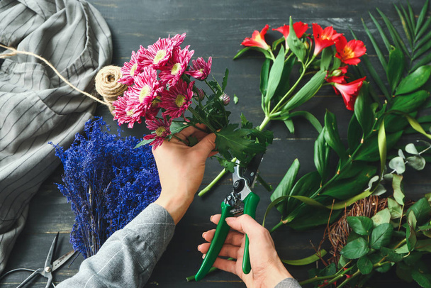 テーブルに美しい花束を作る女性の花屋 - 写真・画像