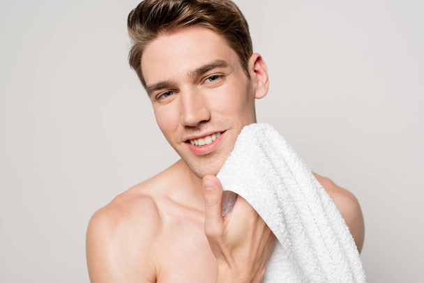 smiling sexy man with muscular torso holding cotton towel isolated on grey - Photo, Image