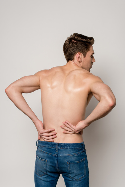 back view of man having backache isolated on grey - Foto, Bild