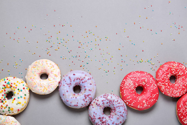 Sweet tasty donuts on grey background - Valokuva, kuva