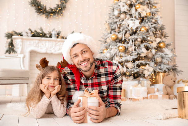Pai feliz e filha pequena com presente de Natal em casa
 - Foto, Imagem