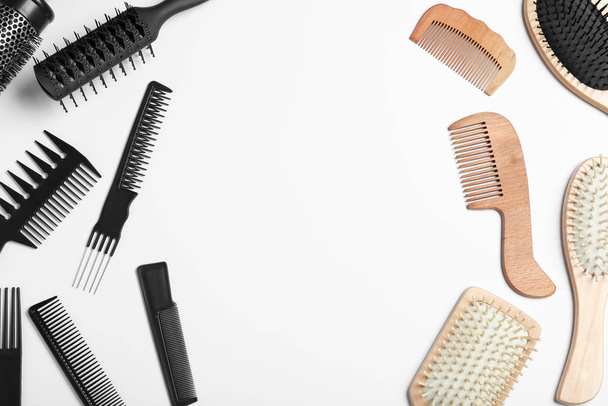 Plastic and wooden hairbrushes on white background, top view. Recycling concept - Foto, Imagen