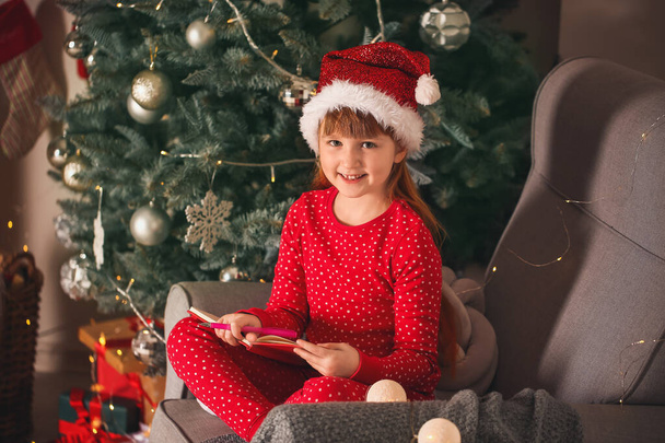 Nettes kleines Mädchen schreibt an Heiligabend Brief an den Weihnachtsmann zu Hause - Foto, Bild