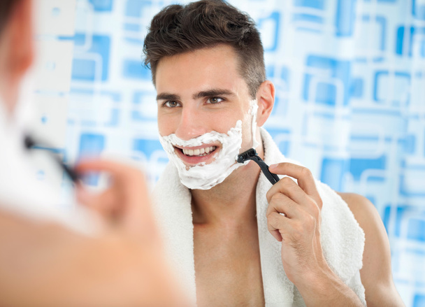 Happy laughing man shaving his face - Foto, Bild