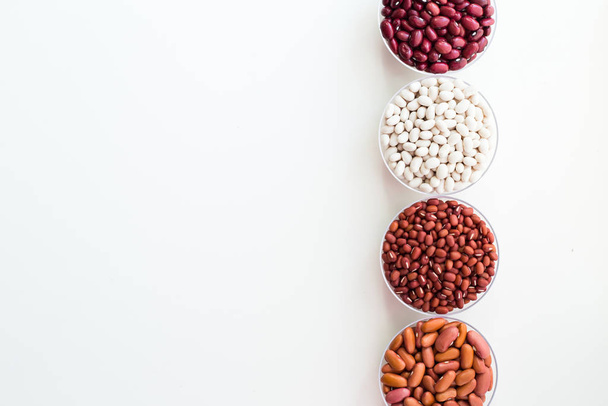 Diferentes granos de semilla en platos redondos están dispuestos en una fila
. - Foto, Imagen