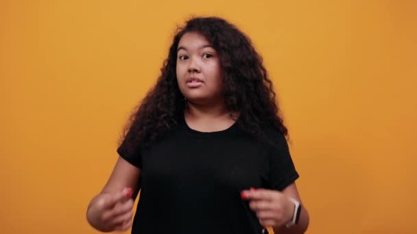 Афро-американская молодая женщина с избыточным весом указывает пальцем на себя
 - Кадры, видео