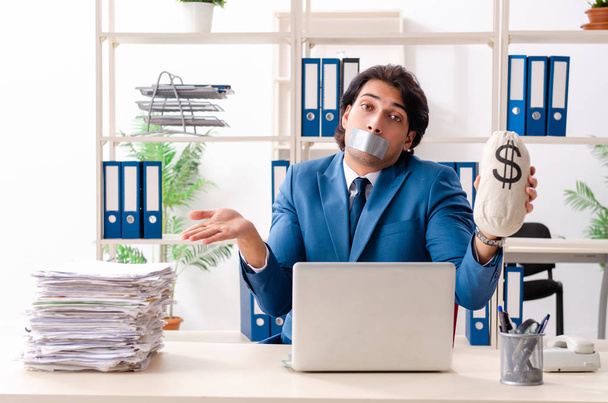 Joven empleado masculino con cinta adhesiva en la boca - Foto, imagen