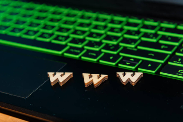 Ξύλινα γράμματα Www βρίσκονται σε ένα πληκτρολόγιο laptop. - Φωτογραφία, εικόνα