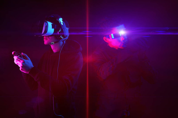 Mann mit Virtual-Reality-Headset und Gamepad und seinem virtuellen Gaming-Avatar. Bild mit Glitch-Effekt. - Foto, Bild