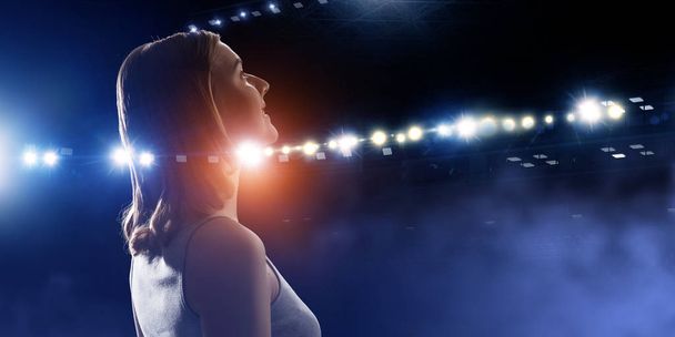 Woman looking at spotlights . Mixed media - Foto, imagen