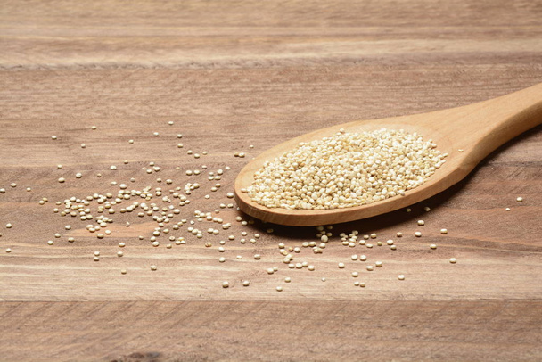 Quinoa cruda in un cucchiaio di legno
 - Foto, immagini