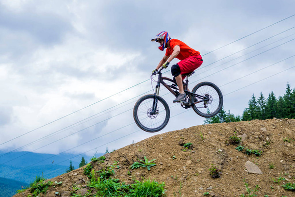 Yokuş aşağı dağ bisikletiyle dağdan inen profesyonel bisikletçi.. - Fotoğraf, Görsel