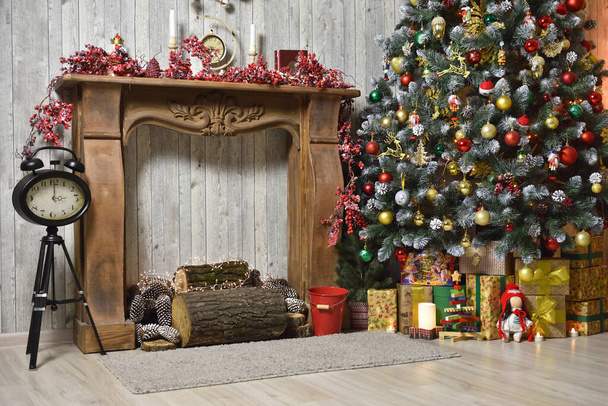 Різдвяний інтер'єр в коричневих тонах з ялинкою, подарунками, дерев'яним каміном і годинником на тринозі
 - Фото, зображення