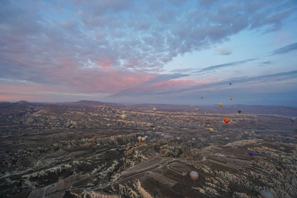 Goreme / Turkey - December 6 2019: noise and grain of mountain hill landscape in Cappadocia with hot air balloon in romantic sunrise moment - Fotografie, Obrázek