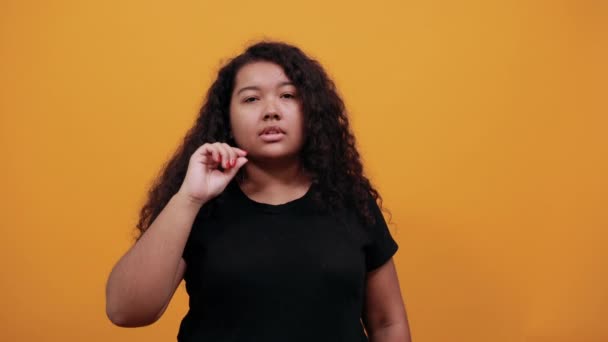 Mujer afroamericana estricta con sobrepeso manteniendo la mano en la boca, mirando hacia arriba
 - Metraje, vídeo