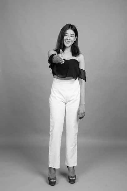 Estúdio tiro de jovem bela mulher asiática contra fundo cinza em preto e branco
 - Foto, Imagem