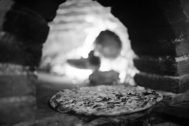 παραδοσιακός πέτρινος φούρνος, πίτσα αστακού είναι η σπεσιαλιτέ του νησιού, αστακός είναι το κύριο προϊόν της αλιείας και κύριο συστατικό πολλών από τα πιάτα του νησιού - Φωτογραφία, εικόνα