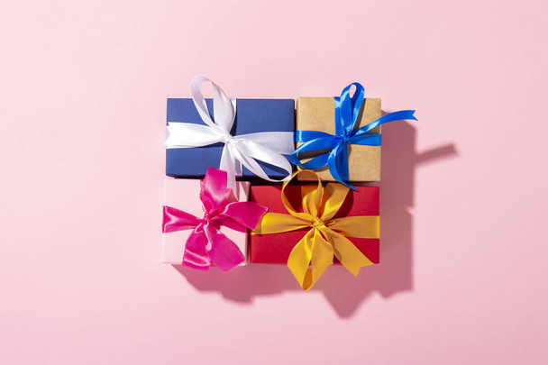 Gifts with a ribbon on a pink background under natural light. Modern. Concept holiday, family, beloved, for him. Banner. Flat lay, top view - Φωτογραφία, εικόνα