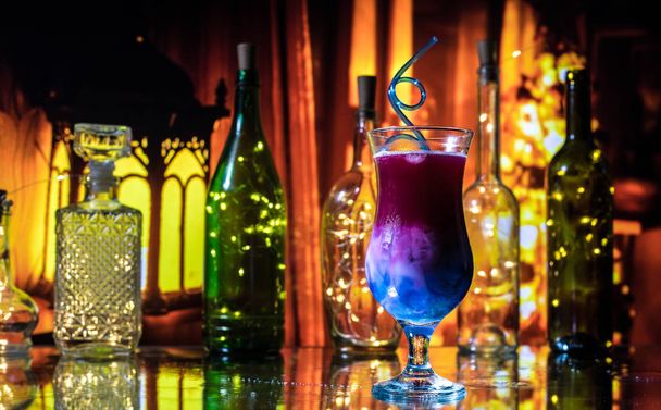 Склянка коктейлю розбризкується на темному тонованому димчастому фоні або барвистому коктейлі в склі. Вечірній клуб розваг. Змішане світло. Вибірковий фокус
 - Фото, зображення