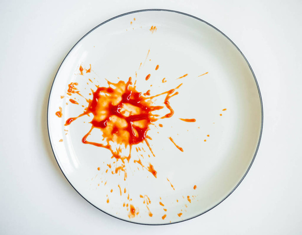 Ketchup-Farbe rot auf weißem Teller, Musterbruch ausgebreitet, weißer Hintergrund - Foto, Bild