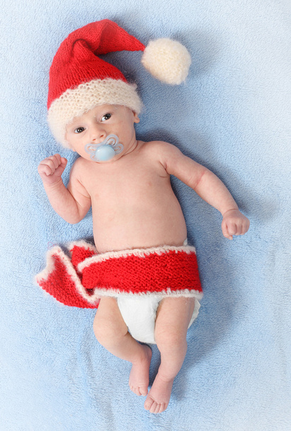 Modefoto eines niedlichen Babys mit lustiger Strickmütze (Weihnachtsmannmütze) für kaltes Wetter - Foto, Bild
