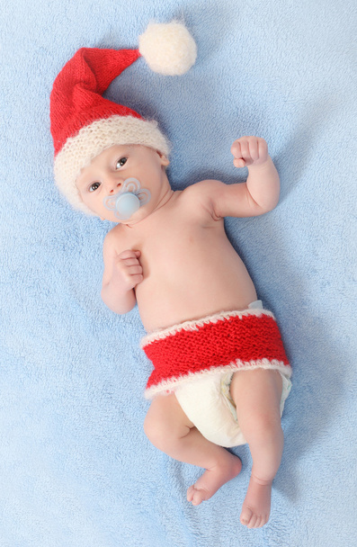 Foto de moda de um bebê bonito com chapéu de malha engraçado (chapéu de Papai Noel) para o tempo frio
 - Foto, Imagem