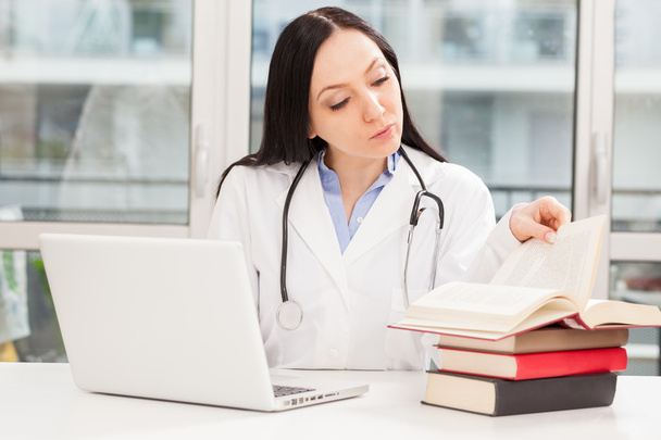 Female doctor is studying with books - Fotó, kép