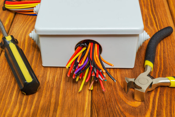 Електрична коробка з кабелями дроти та інструменти, що використовуються в процесі електромонтажу
 - Фото, зображення
