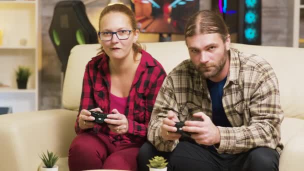 Εστιασμένο ζευγάρι που παίζει online βιντεοπαιχνίδια κάθεται στον καναπέ - Πλάνα, βίντεο