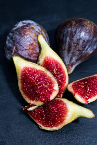 open natural black figs isolated on black background - Foto, afbeelding