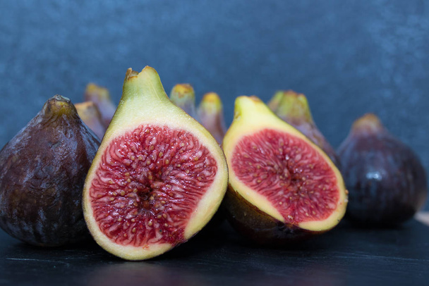 natural black figs grouped and open on black background - Foto, immagini