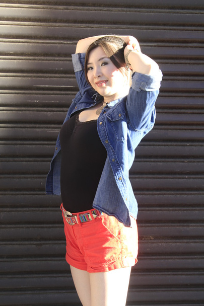 Asian model posing in front of garage door. - Φωτογραφία, εικόνα