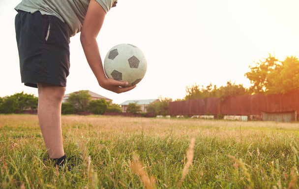 Кавказький хлопчик з футбольним м'ячем на футбольному полі.. - Фото, зображення