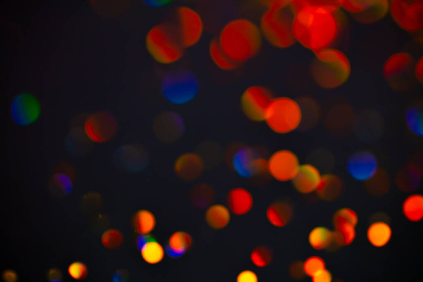 Multicolor glitter raster background. Abstract shimmering red circles on deep purple backdrop. Vibrant bokeh lights effect festive illustration. Overlapping glowing and twinkling spots. - Foto, imagen