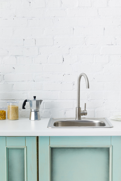 modern white and turquoise kitchen interior with kitchenware and sink near brick wall - Φωτογραφία, εικόνα