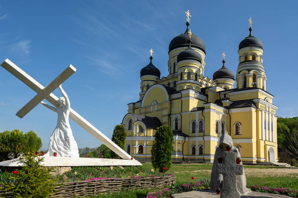 Iglesia ortodoxa en el territorio del monasterio de Hincu en Moldavia. Escultura de Jesucristo llevando la cruz en primer plano
 - Foto, imagen