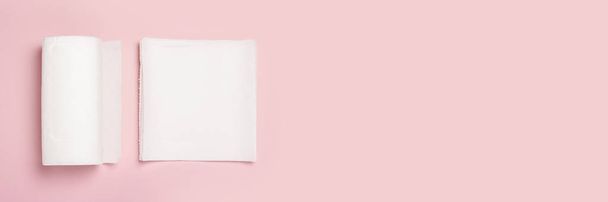 Role papírových ručníků a několik kusů ručníků na růžovém pozadí. Koncept je 100 přírodní produkt, jemný a měkký. Plocha, výhled shora. Nápis - Fotografie, Obrázek